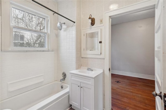 bathroom featuring hardwood / wood-style flooring, vanity, and tiled shower / bath combo