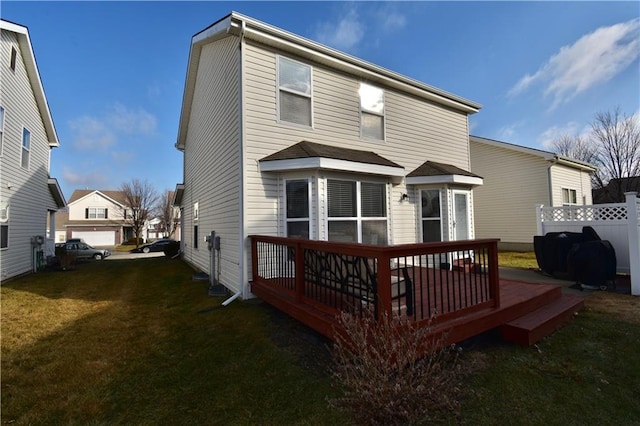 rear view of property with a wooden deck and a yard