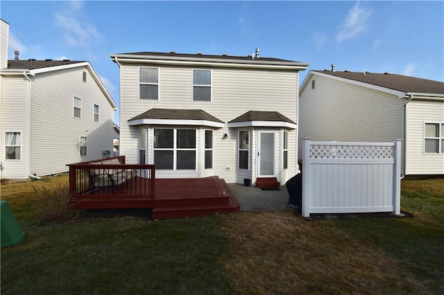 back of house with a deck and a lawn