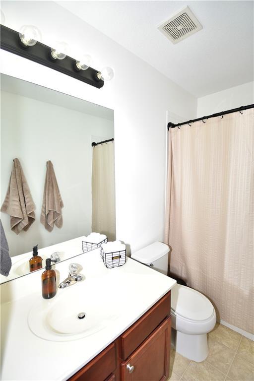 bathroom with vanity, tile patterned floors, and toilet