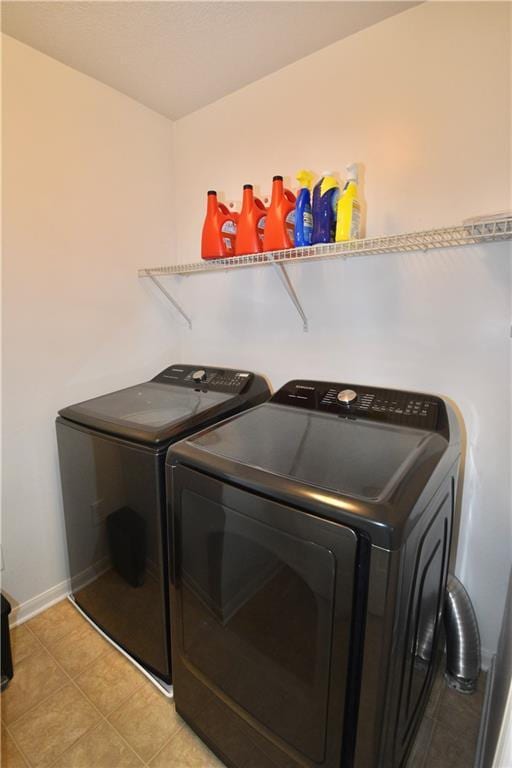 laundry room featuring light tile patterned floors and washer and clothes dryer