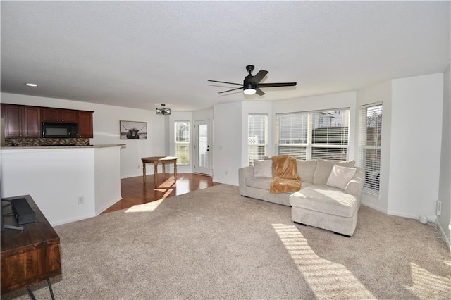 carpeted living room with a healthy amount of sunlight and ceiling fan