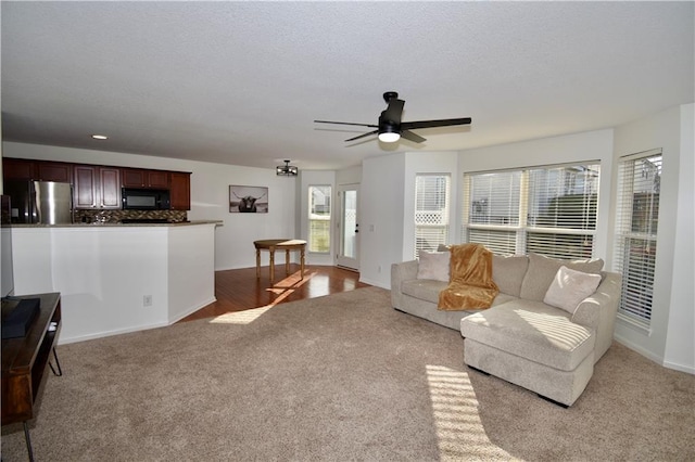 carpeted living room with ceiling fan