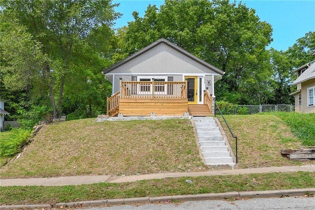 bungalow featuring a front yard and a deck