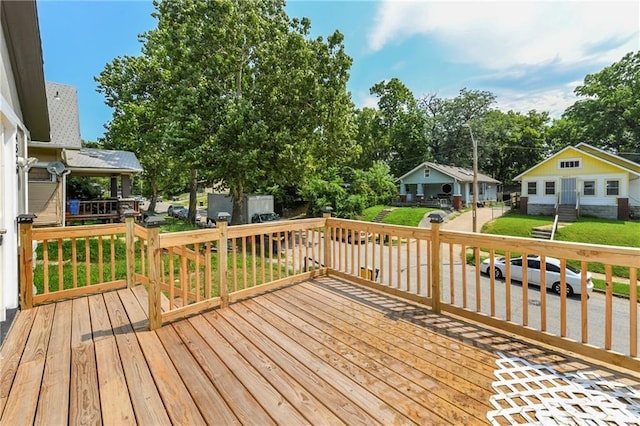 wooden deck featuring a lawn