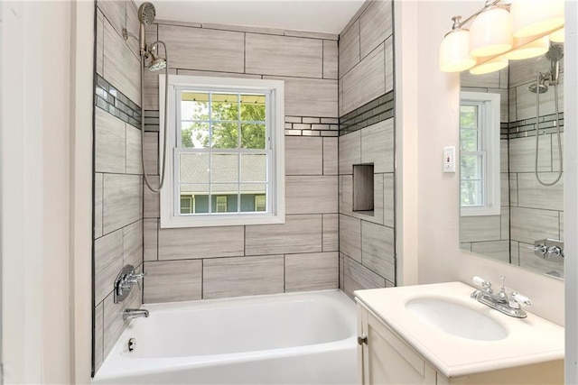 bathroom featuring tiled shower / bath and vanity