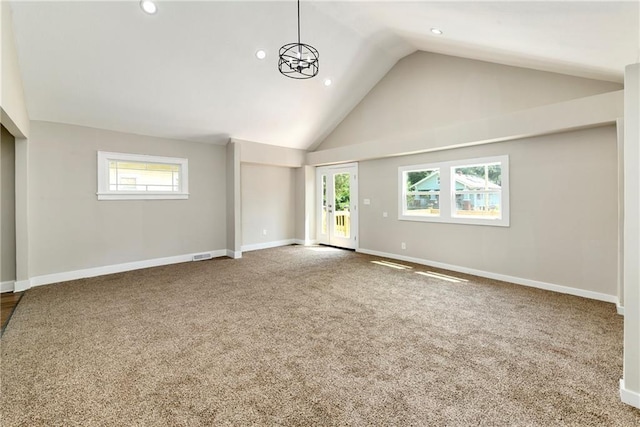 unfurnished living room featuring plenty of natural light, high vaulted ceiling, and carpet