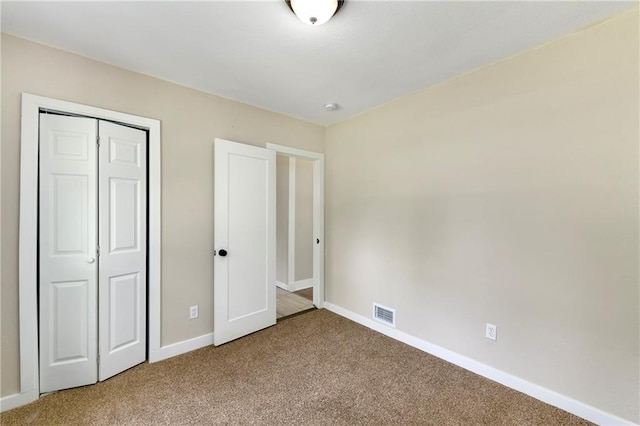 unfurnished bedroom featuring carpet and a closet