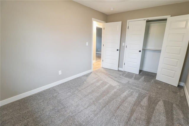 unfurnished bedroom with dark carpet and a closet