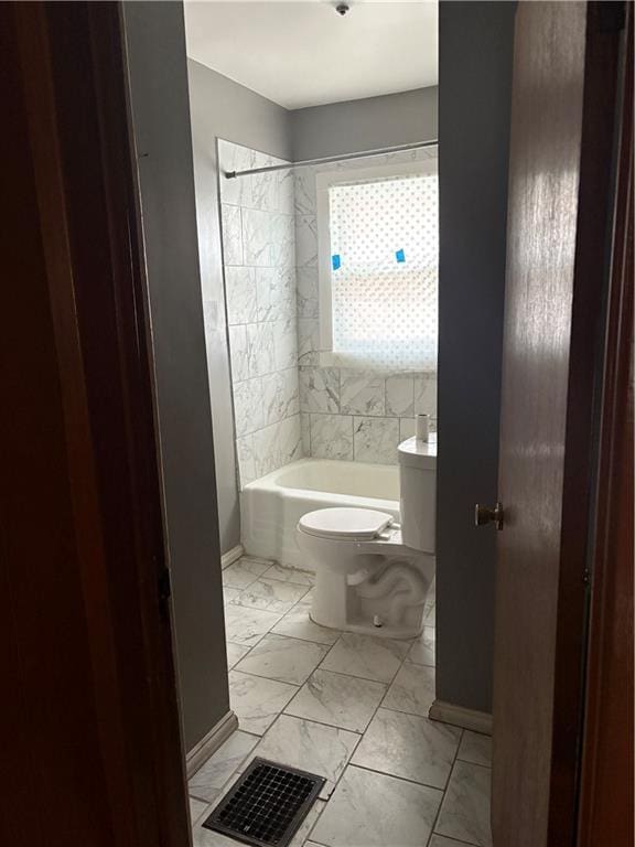 bathroom featuring tiled shower / bath and toilet