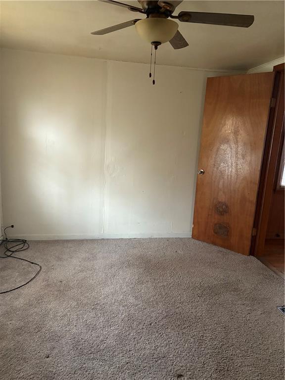 carpeted spare room with ceiling fan