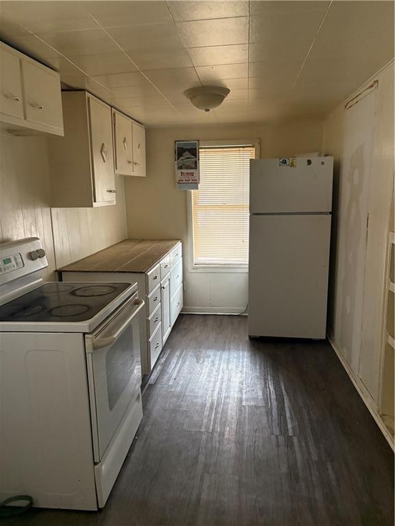 kitchen featuring white appliances, dark hardwood / wood-style flooring, and white cabinets