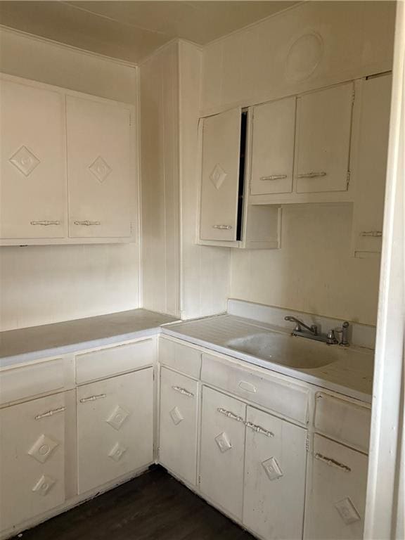 kitchen featuring white cabinetry, dark hardwood / wood-style flooring, and sink