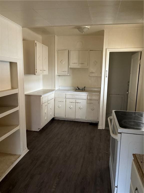 kitchen with electric stove, sink, dark hardwood / wood-style floors, and white cabinets