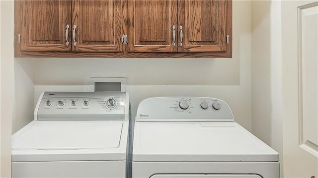 laundry room with washing machine and dryer and cabinets