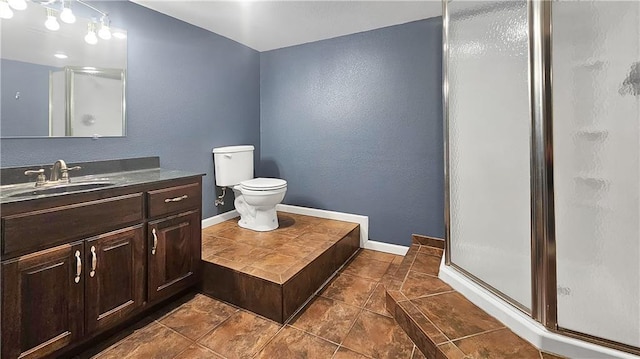 bathroom featuring vanity, tile patterned flooring, toilet, and walk in shower