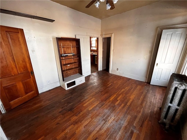 unfurnished bedroom featuring ceiling fan and dark hardwood / wood-style flooring