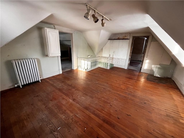 bonus room with radiator, dark wood-type flooring, and lofted ceiling