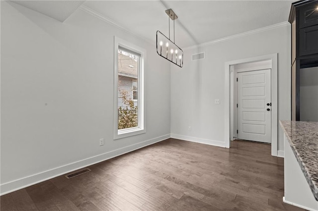 unfurnished dining area featuring ornamental molding, dark wood-type flooring, and a chandelier