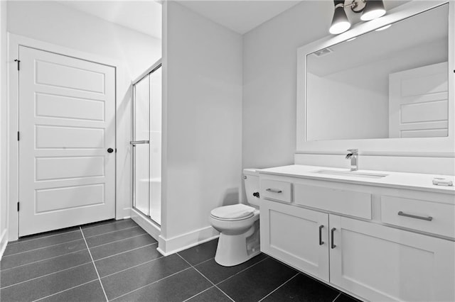 bathroom featuring walk in shower, vanity, toilet, and tile patterned flooring