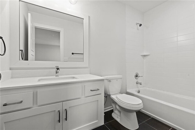 full bathroom featuring vanity, tile patterned floors, toilet, and tiled shower / bath