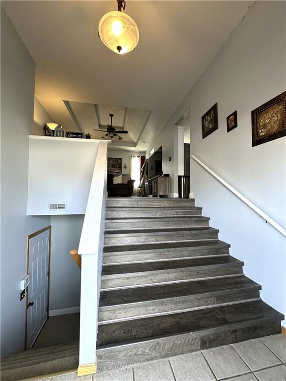 staircase with tile patterned flooring and ceiling fan