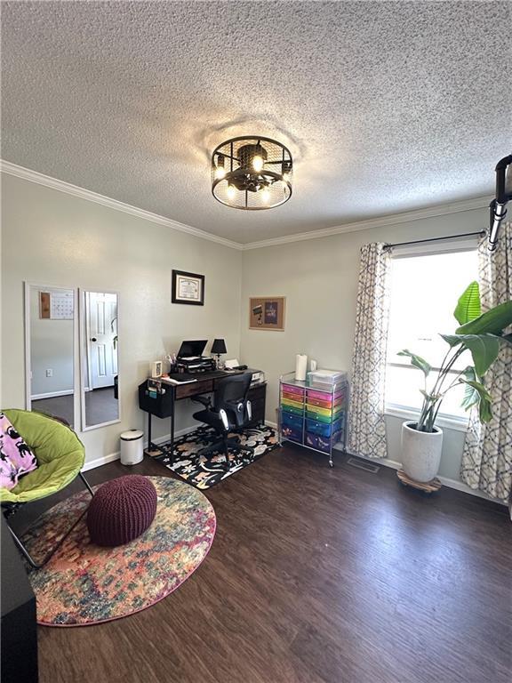 office space with dark wood-type flooring, ornamental molding, a chandelier, and a textured ceiling