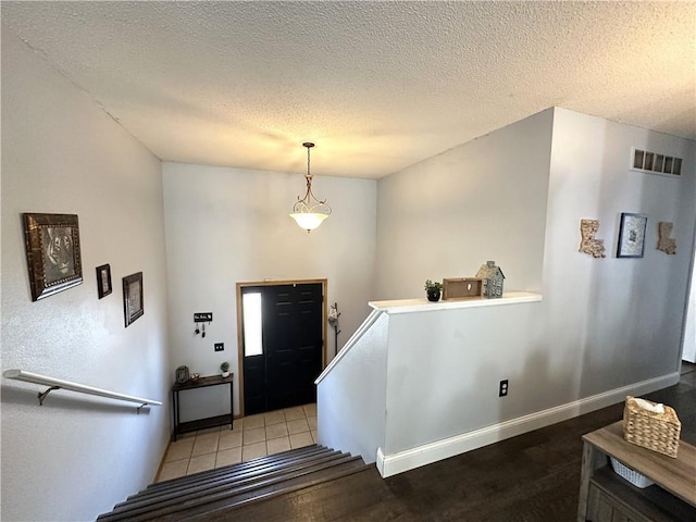 tiled entryway featuring a textured ceiling