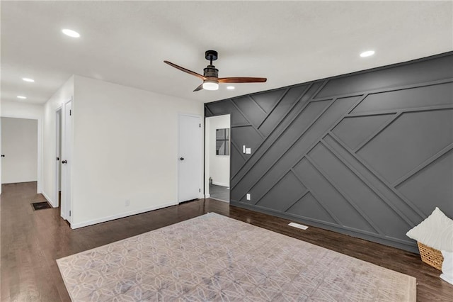 empty room featuring dark wood-type flooring and ceiling fan