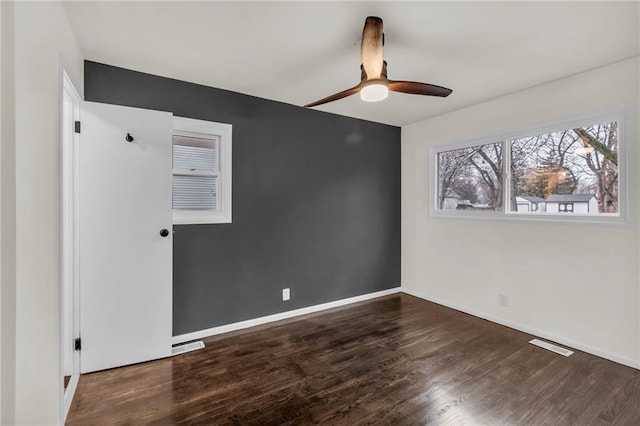 empty room with dark hardwood / wood-style floors and ceiling fan