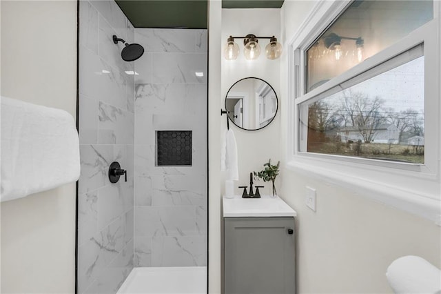 bathroom featuring vanity, plenty of natural light, and tiled shower