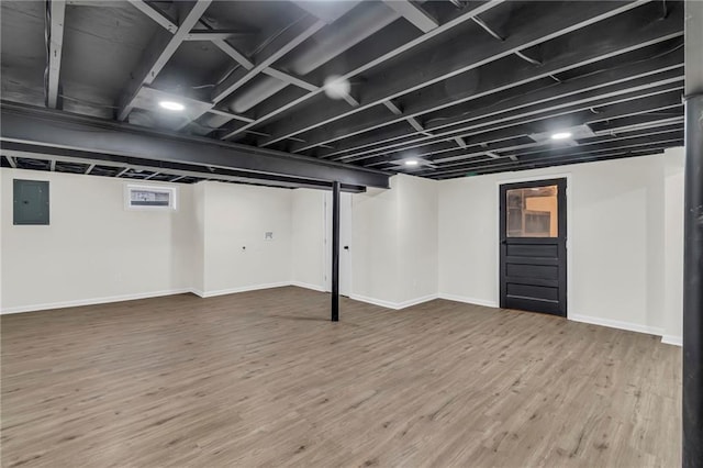 basement with wood-type flooring and electric panel