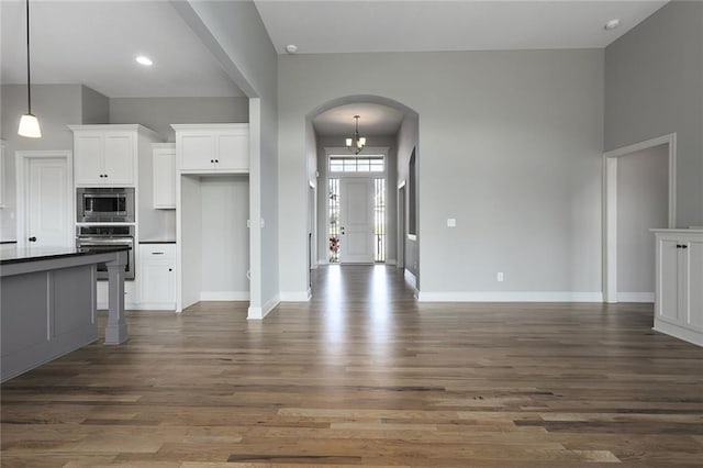 kitchen featuring white cabinetry, decorative light fixtures, dark hardwood / wood-style floors, and appliances with stainless steel finishes