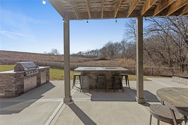 view of patio featuring an outdoor kitchen, exterior bar, and area for grilling