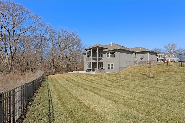 rear view of property with a yard, a patio, and a balcony