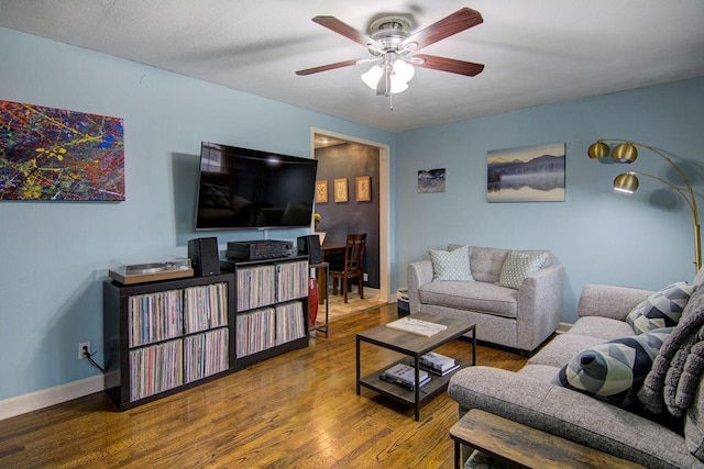 living room with wood-type flooring and ceiling fan