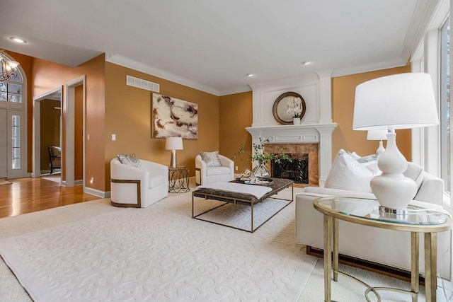 living room featuring a tiled fireplace and ornamental molding