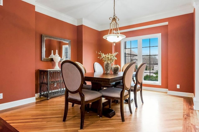 dining room featuring ornamental molding and light hardwood / wood-style floors