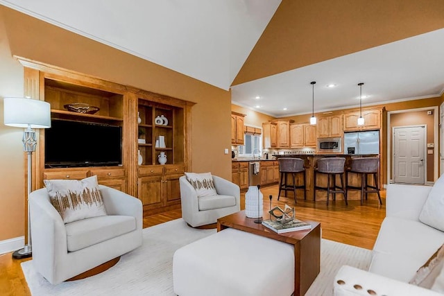 living room with high vaulted ceiling, ornamental molding, and light hardwood / wood-style floors