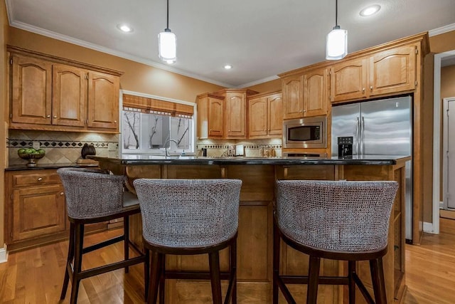 kitchen featuring stainless steel microwave, pendant lighting, a kitchen breakfast bar, and a kitchen island