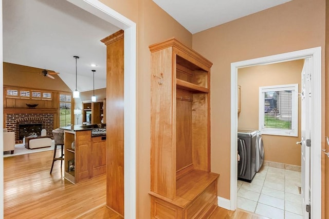 mudroom with ceiling fan, independent washer and dryer, a wealth of natural light, and a fireplace