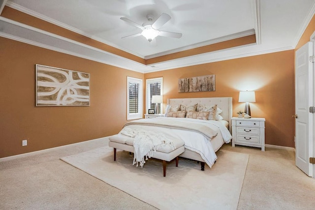 carpeted bedroom with a raised ceiling, crown molding, and ceiling fan