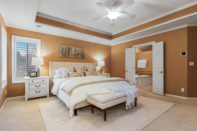 carpeted bedroom featuring crown molding, ceiling fan, ensuite bathroom, and a raised ceiling