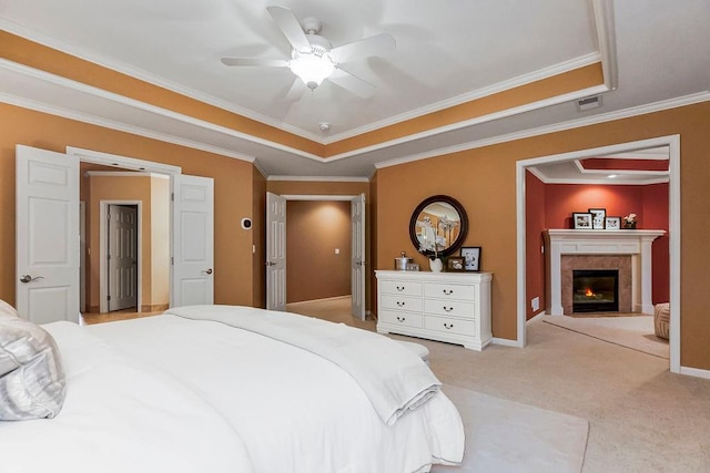 carpeted bedroom featuring crown molding, ceiling fan, and a tray ceiling