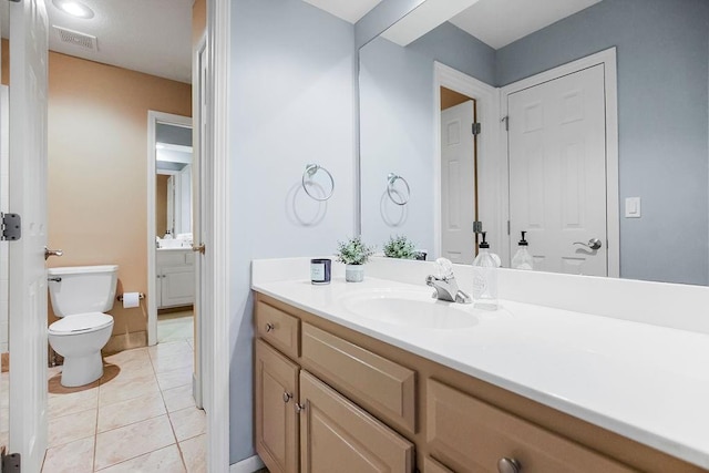 bathroom with vanity, tile patterned floors, and toilet