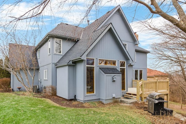 back of property with a wooden deck and a lawn