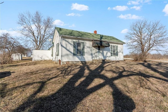 view of front of property with a front yard and a chimney