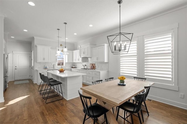 dining room featuring crown molding, dark hardwood / wood-style flooring, and sink