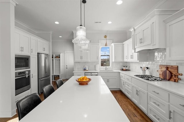 kitchen with a breakfast bar area, white cabinetry, tasteful backsplash, decorative light fixtures, and appliances with stainless steel finishes