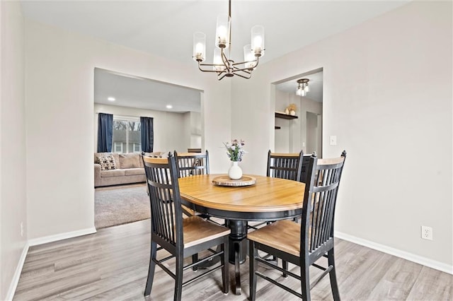 dining area featuring light hardwood / wood-style flooring and a notable chandelier